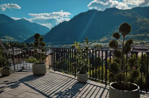 a balcony with potted plants and a view of mountains at Freiraum 9 Living Apartment in Sankt Johann im Pongau
