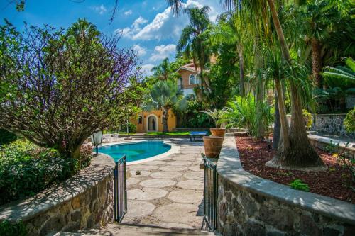 a home with a swimming pool and palm trees at ANANA Rancho San Rafael Pool and Lake Views in Ajijic