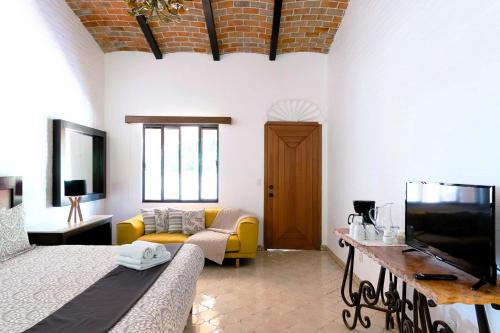 a living room with a couch and a tv at ANANA Rancho San Rafael Pool and Lake Views in Ajijic