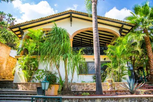 a house with palm trees in front of it at ANANA Rancho San Rafael Pool and Lake Views in Ajijic