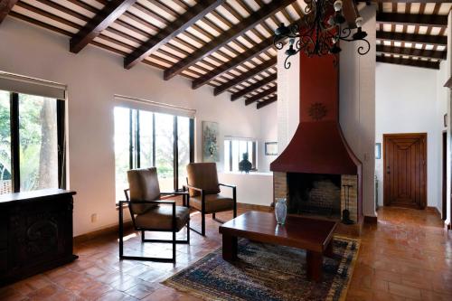 a living room with a fireplace and a table and chairs at ANANA Rancho San Rafael Pool and Lake Views in Ajijic