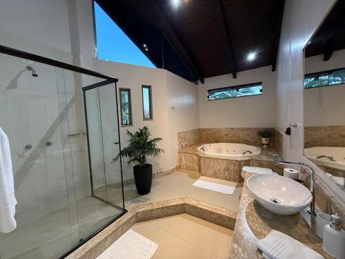 Un baño con ducha, lavabo y bañera. en Pousada Casa da Praia, en São Francisco do Sul