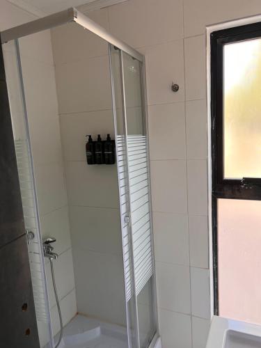 a shower with a glass door in a bathroom at La Misión Tiny Houses in Ciudad Lujan de Cuyo