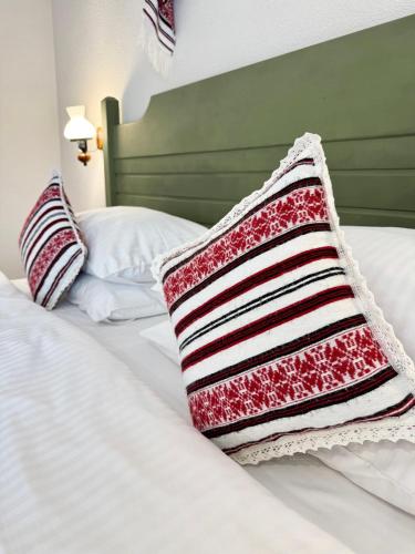 a red and white striped pillow on a bed at Krystal Boutique Mansion in Hunedoara