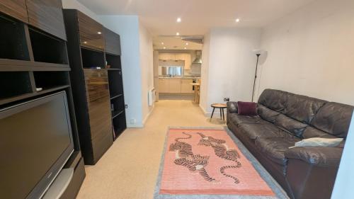 a living room with a couch and a television at Beautiful and Central Apartment in Newcastle City in Central Station