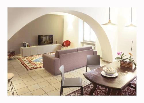 a living room with a couch and a table at Due dei Mille. Incantevole casa in centro ad Alba in Alba
