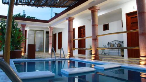 a house with a swimming pool in front of a house at Hotel Las Mestizas Valladolid in Valladolid