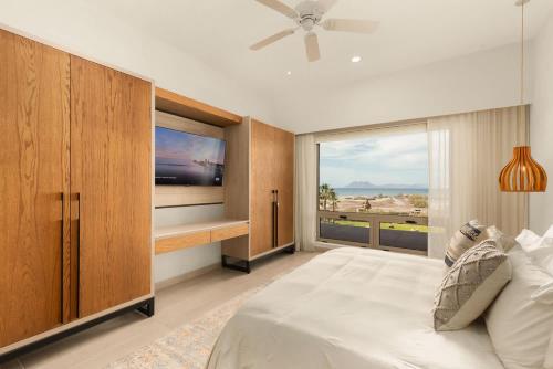 una camera da letto con un letto grande e una grande finestra di Stylish Summer 2BR Retreat w Pool & Beach Access a Ensenada Blanca
