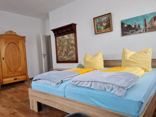 a bedroom with two beds with yellow and blue pillows at Gambrinus Schneeberg in Schneeberg