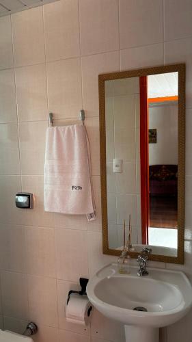 a bathroom with a sink and a mirror and a towel at Bike Ville Fojo in Campos do Jordão