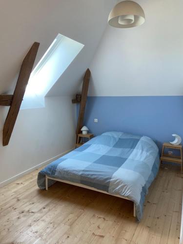 a bedroom with a bed with a blue comforter at Gite 8-10 pers, 4 chambres, billard, jardin in La Bouexière