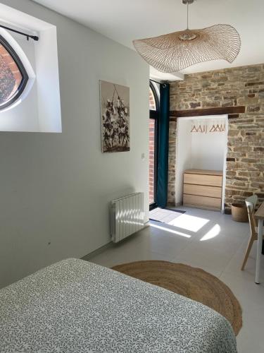 a bedroom with a bed and a brick wall at Gite 8-10 pers, 4 chambres, billard, jardin in La Bouexière
