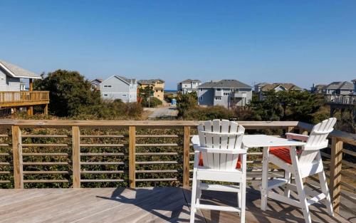 two white chairs and a table on a deck at Downtown Duck Resort Perks Ocean Views & Hot Tub in Duck