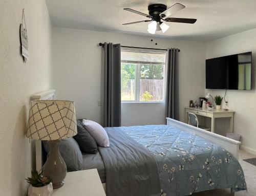 a bedroom with a bed and a ceiling fan at Charming Suite with privacy in Sacramento
