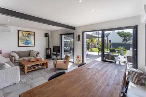 un salon avec une table et un canapé dans l'établissement Parenthèse idéale - Villa d'Exception à Carnac Vue Mer Panoramique, à Carnac