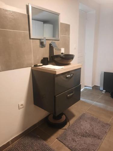 une salle de bain avec un lavabo noir et un miroir dans l'établissement La détente, à Féchain
