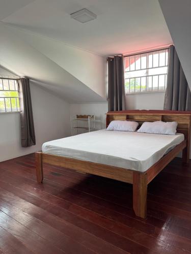 a bedroom with a bed with white sheets and two windows at Garnizoenspad appartementen in Baskamp