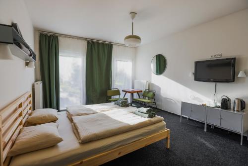a bedroom with a bed and a tv on the wall at Prague Camping Dzban in Prague