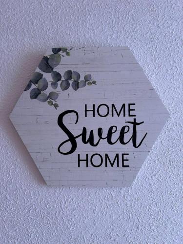 a sign with the words home sweet home on a wall at Ático con Terraza en Isla in Isla