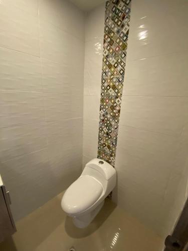 a bathroom with a white toilet in a room at La Rosita in Puerto Colombia
