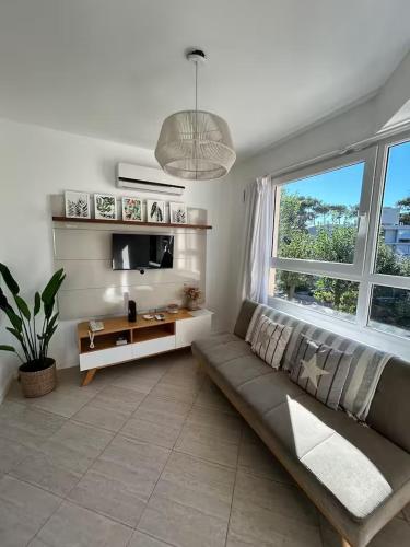 a living room with a couch and a large window at Sea Point By D&G in Carilo