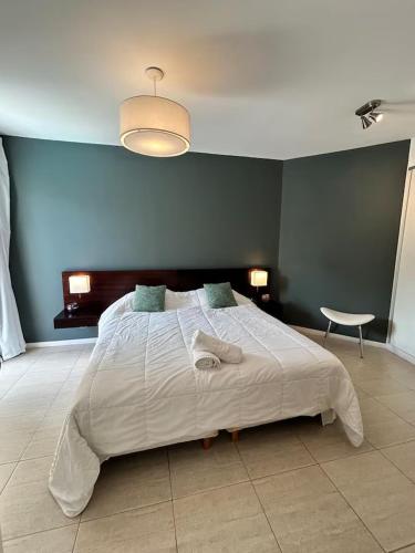a bedroom with a large bed with a blue wall at Sea Point By D&G in Carilo