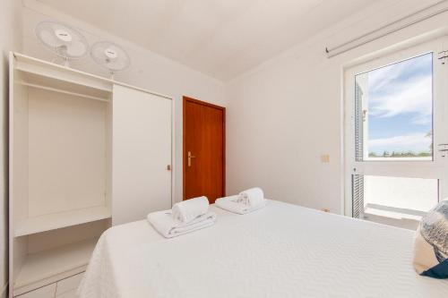 a white bedroom with a bed and a window at B75 - Casa Delfim in Alfanzina Carvoeiro in Carvoeiro