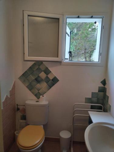 une salle de bain avec toilettes, lavabo et fenêtre dans l'établissement Villa individuelle avec jardin, à Sartène