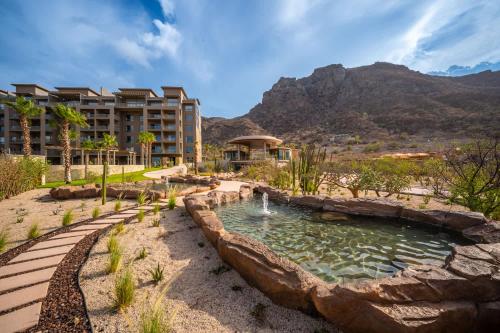 Ensenada BlancaにあるDanzante Bay Oceanfront 2 BR Beach & Golfの池と山を背景にしたリゾート