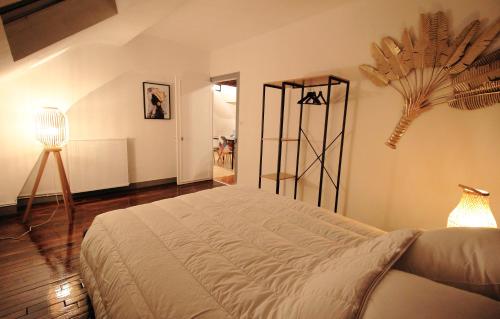 une chambre avec un grand lit et une lampe dans l'établissement T2 Tudelle - Le Perché, à Orléans