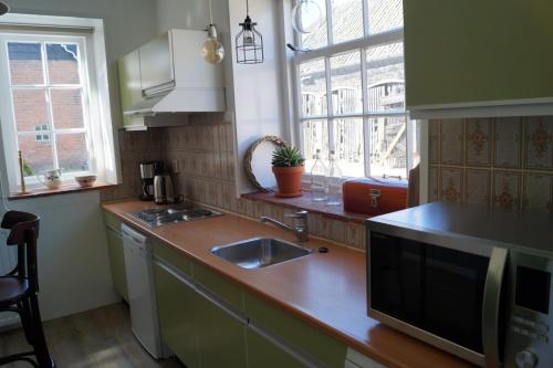 a kitchen with a sink and a counter top at Vakantiehuis 't Boerenhuis in Aagtekerke