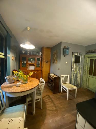 a dining room with a table and chairs and a kitchen at Chata pod Żurawiem 