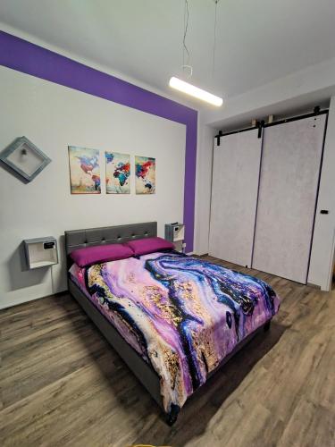 a bedroom with a large bed with purple walls at L'angolo del Viaggiatore 5 Terre in La Spezia