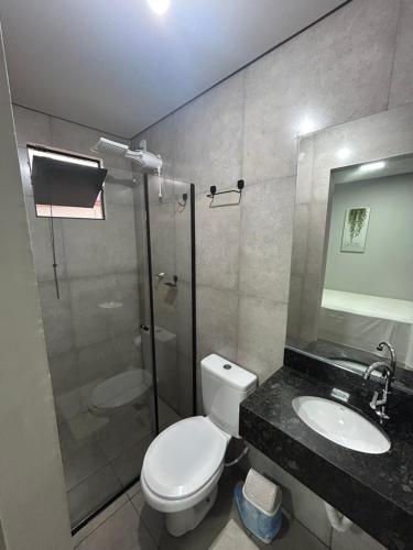 a bathroom with a shower and a toilet and a sink at Hotel GranDourados in Dourados