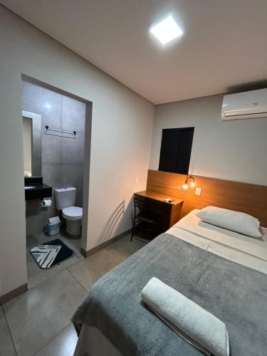 a bedroom with a bed and a sink and a toilet at Hotel GranDourados in Dourados