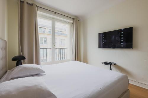 une chambre avec un lit blanc et une fenêtre dans l'établissement Wonderfull apartment - 1BR-6P - Eiffel Tower, à Paris