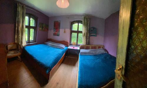 a bedroom with two beds with blue sheets at Chata pod Żurawiem 