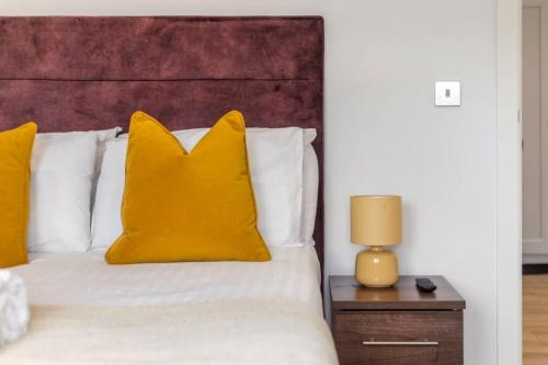 a bedroom with a bed with yellow pillows at Pet-friendly apt in Shenfield in Shenfield