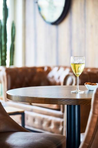 a glass of wine sitting on a table at Ibis Styles Hyères Rooftop & Spa in Hyères