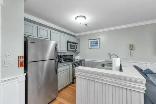 a kitchen with a stainless steel refrigerator and white cabinets at Lakeview Escape, Pool, Fast Wi-Fi & Free Parking in Laconia