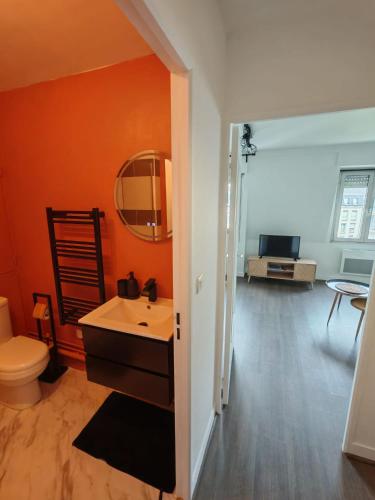 La salle de bains orange est pourvue d'un lavabo et de toilettes. dans l'établissement Le Bel Horizon, à Chartres