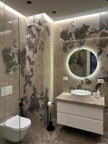 a bathroom with a sink and a mirror at Bright & Modern Family Flat in Tirana