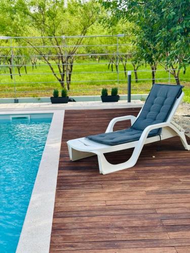 a lounge chair sitting next to a swimming pool at Almond Buna PoolHouse in Mostar