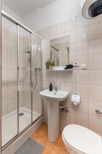 a bathroom with a shower and a sink and a toilet at Hostel Coco in Warsaw