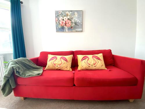 een rode bank met twee gele kussens erop bij BridgeView Central Cambridge with Parking Off Site F6 in Cambridge