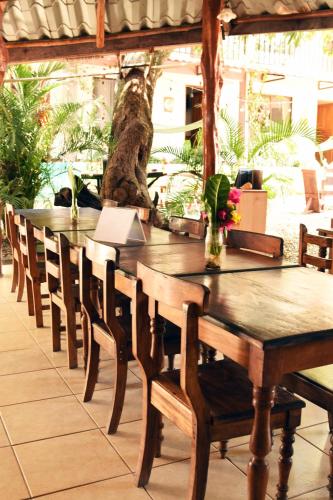 a long wooden table and chairs in a restaurant at La Posada - Hostel in Santa Teresa Beach