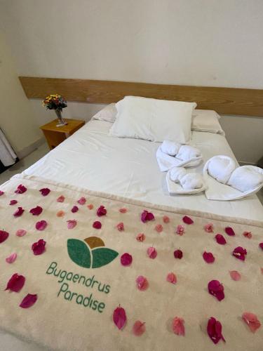 a bed with roses on it with towels on it at Pousada Bugaendrus in Touros
