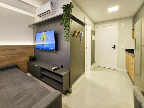 a living room with a flat screen tv on a wall at Skyline Parque Moinhos by LikeHome in Floresta