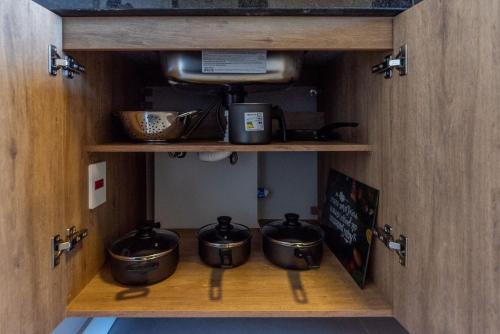 a kitchen with pots and pans in a cabinet at Skyline Parque Moinhos by LikeHome in Floresta