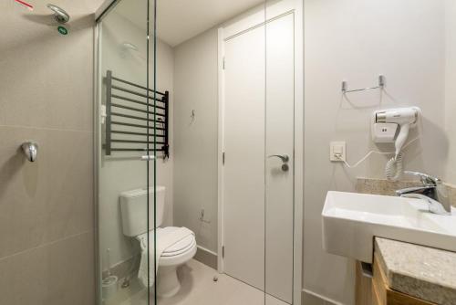 a bathroom with a toilet and a shower and a sink at Skyline Parque Moinhos by LikeHome in Floresta